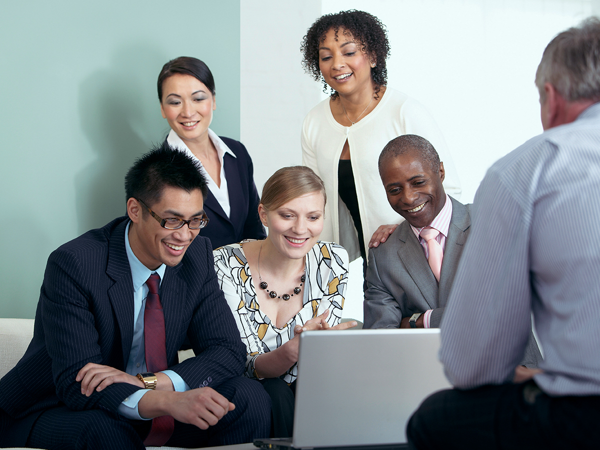 she demonstrates technical leadership with her staff as they gather in front of a laptop