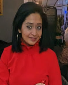 Professional woman in red dress holding wine bottle at evening event