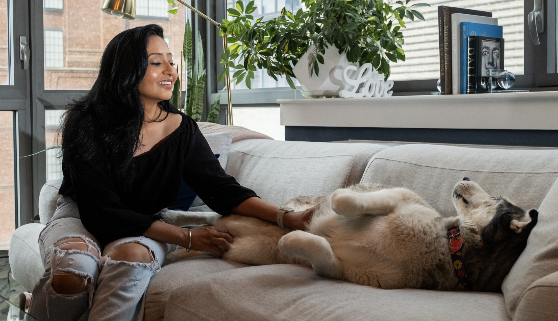 a girl petting her dog on the couch